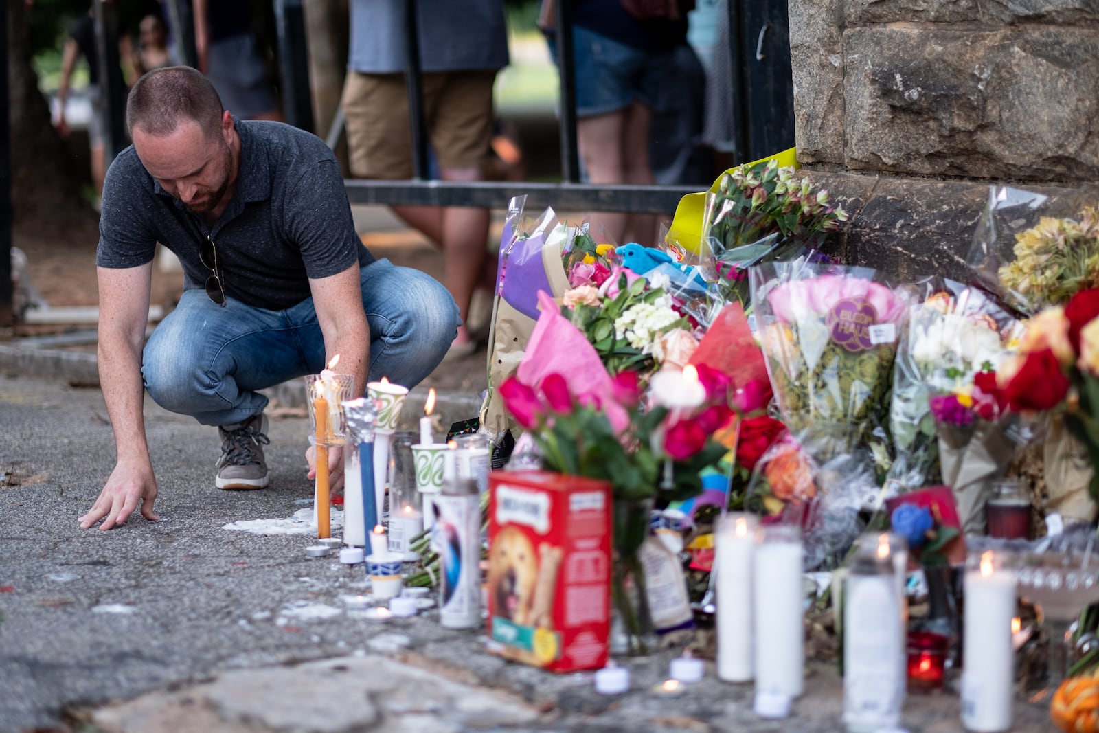 Josh Noblitt leaves a candle following a vigil for stabbing victim Katherine Janness on Sunday at Piedmont Park.