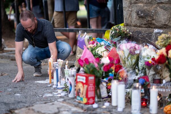 Josh Noblitt leaves a candle following a vigil for Katie Janness on Aug. 1 at Piedmont Park. Ben Gray for the Atlanta Journal-Constitution