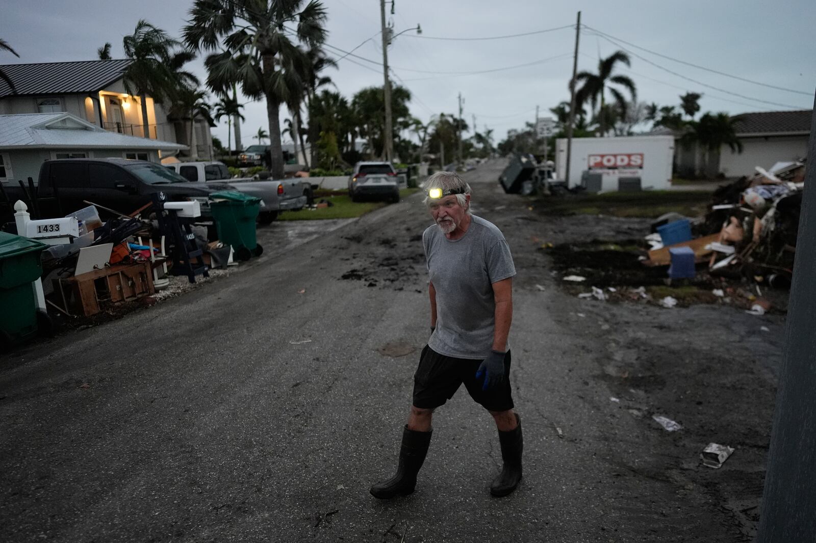 Robert Turick, 68, walks on his street as he and other neighbors work to remove debris swept onto their properties by Hurricane Milton storm surge, in Englewood, Fla., Friday, Oct. 11, 2024. (AP Photo/Rebecca Blackwell)