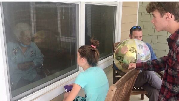 Jeanette Hicks, a resident of Orchard View nursing home in Columbus, celebrated her 93rd birthday in October through the window with her family, including her great-grandchildren. The family had to mail a birthday cake. (Photo courtesy of the family)