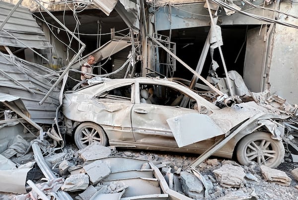 A man checks his destroyed shop at a street that was hit in an Israeli airstrike in Dahiyeh, in the southern suburb of Beirut, Lebanon, Thursday, Nov. 14, 2024. (AP Photo/Hussein Malla)