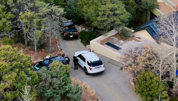 Law enforcement officials talk outside the home of actor Gene Hackman on Thursday, Feb. 27, 2025 in Santa Fe, New Mexico. Hackman, his wife Betsy Arakawa and their wife were found dead in the home a day earlier. (AP Photo/Roberto Rosales)