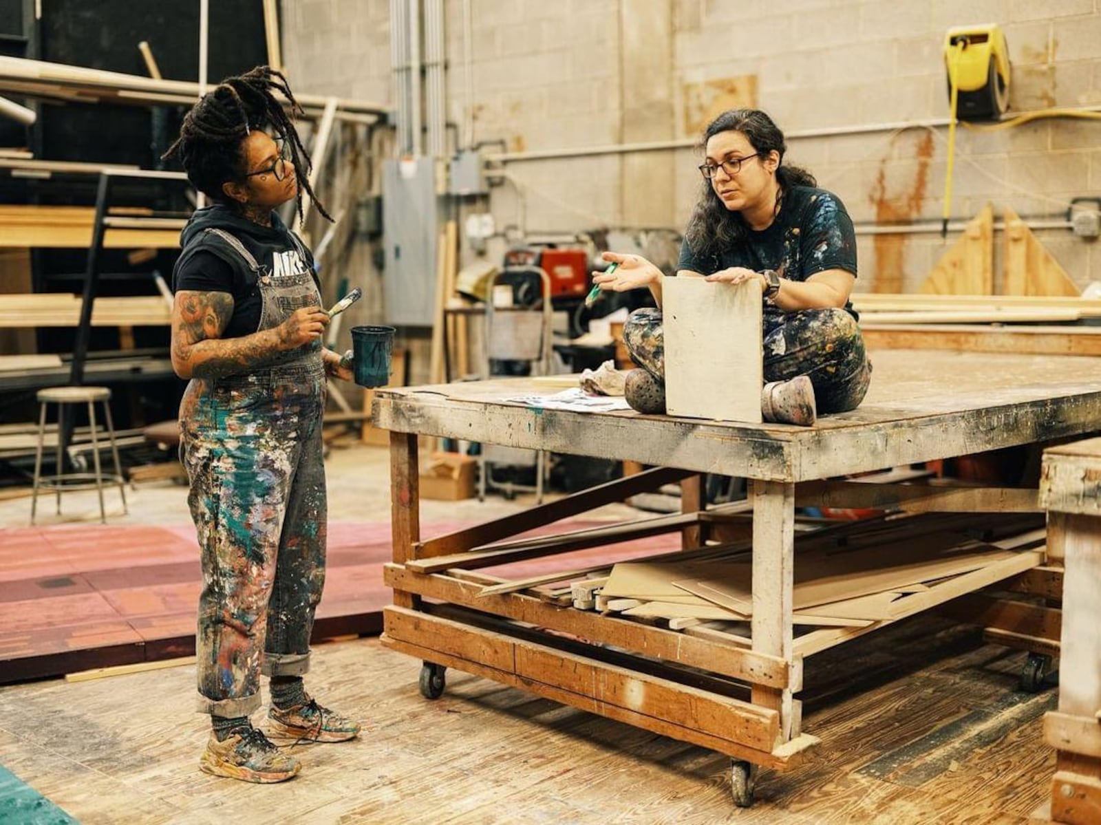 Muralist Charity Hamidullah talks with scenic artist Angela Bartone in Atlanta Ballet's scene shop.
(Courtesy of Andrew Thomas Clifton)