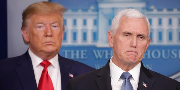 President Donald Trump, left, listens to Vice President Mike Pence, right, as he pauses while speaking to members of the media to address the nation about the coronavirus threat.