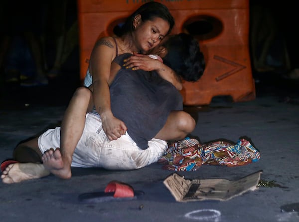 FILE- Jennilyn Olayres cuddles her live-in partner alleged drug user and pusher Michael Siaron, after he was killed by unknown assailants at an intersection in Pasay city south of Manila, Philippines, July 23, 2016. (AP Photo/Linus G. Escandor II, File)