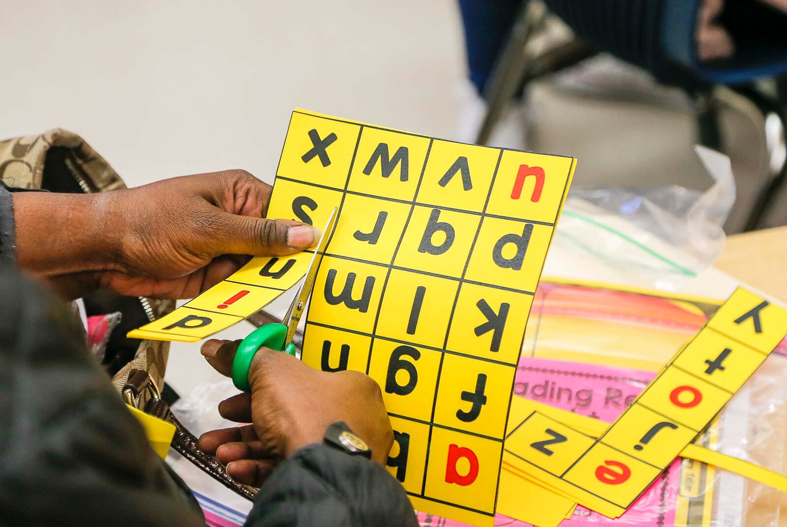 A first grade parent cuts out letters for at home learning with their child during an Academic Parent Teacher Teams meeting after school, Monday, January 21, 2020. Teachers encouraged parents to engage their students academically when they are away from the classroom in order to encourage continuous learning. (ALYSSA POINTER/ALYSSA.POINTER@AJC.COM)