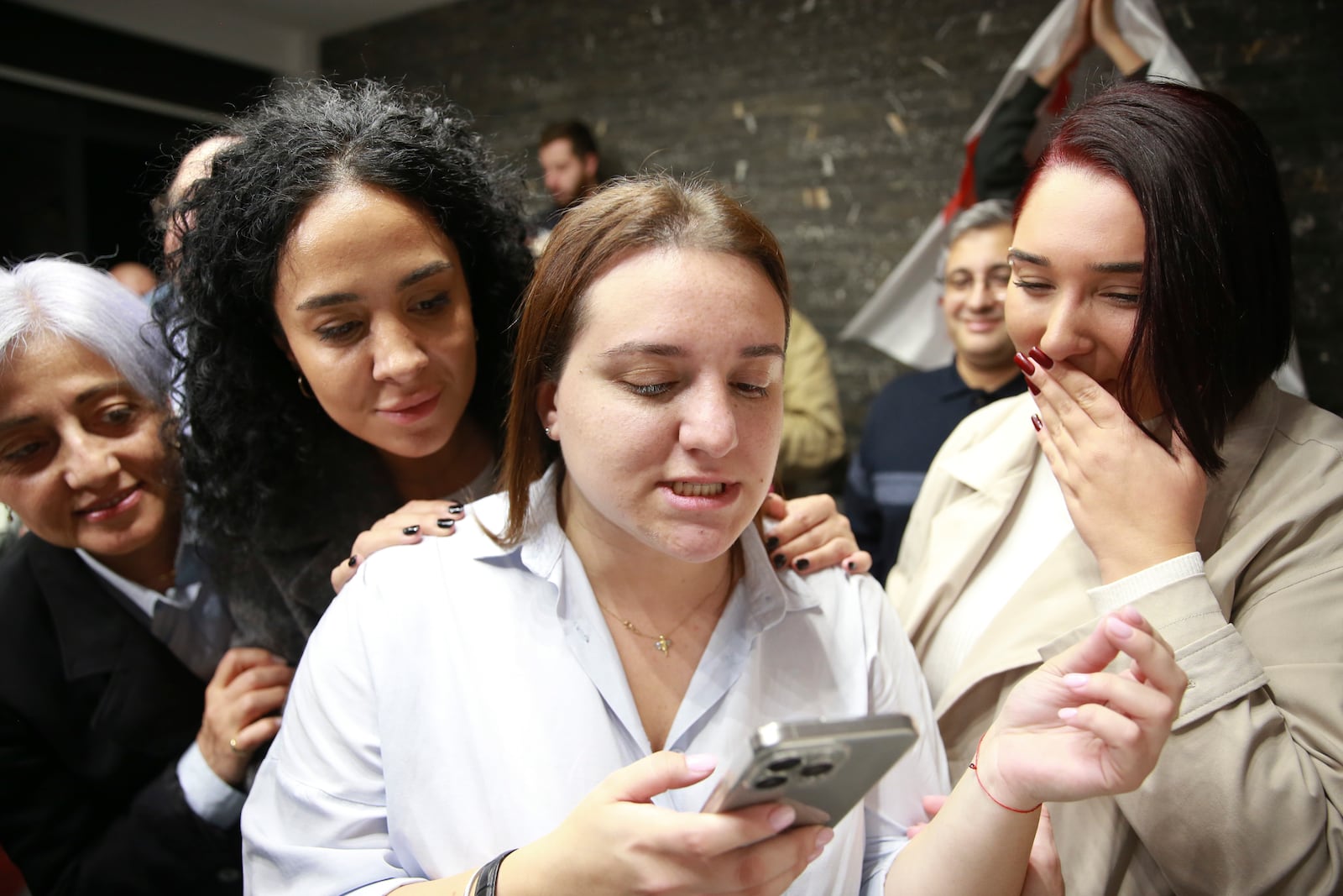 Supporters of the Coalition for Change look at the phone at coalition's headquarters after polls closing at the parliamentary election in Tbilisi, Georgia, Saturday, Oct. 26, 2024. (AP Photo/Zurab Tsertsvadze)