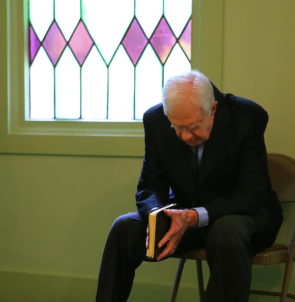 Jimmy Carter, 89, holds his Bible and prays silently in the sanctuary as he waits to be introduced to the congregation to teach the Sunday School lesson at Maranatha Baptist Church on Sunday, June 15, 2014, in Plains. CURTIS COMPTON / CCOMPTON@AJC.COM