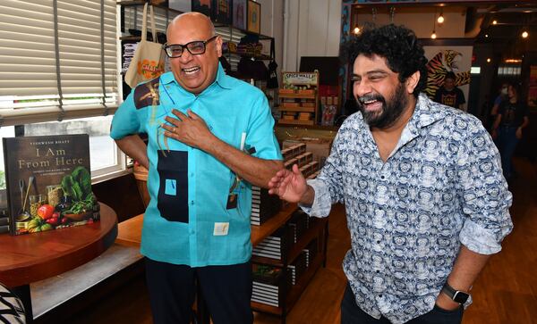 Chef Vishwesh Bhatt (left) and longtime friend chef Meherwan Irani have a laugh before dinner service on Aug. 9, 2022, in the lobby and greeting area of Chai Pani in downtown Decatur. Irani, executive chef and founder of Chai Pani, held the event to celebrate the release of his friend's first cookbook, ”I Am From Here: Stories and Recipes From a Southern Chef.” (Chris Hunt for the AJC)