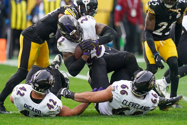 Baltimore Ravens running back Derrick Henry (22) scores a touchdown as Pittsburgh Steelers safety Minkah Fitzpatrick, top left, and safety DeShon Elliott, top right, try to stop him during the first half of an NFL football game, Sunday, Nov. 17, 2024, in Pittsburgh. Ravens' Patrick Ricard (42) and Ben Cleveland (66) hit the ground on the play. (AP Photo/Matt Freed)