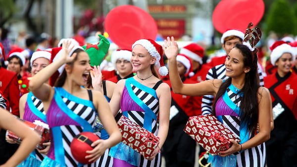 Members of the Seminole Ridge High School Hawk Marching Band wave to the crowd during the Wellington holiday parade along Forest Hill Boulevard.  (Richard Graulich / The Palm Beach Post)