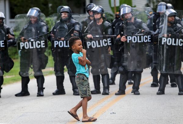 8/15/20 - Stone Mountain, GA - James Armour, 6, looks toward his mom before he talks to police as several far-right groups, including militias and white supremacists, rally Saturday in the town of Stone Mountain, and a broad coalition of leftist anti-racist groups organized a counter-demonstration there after local authorities closed Stone Mountain park.   Jenni Girtman for the Atlanta Journal Constitution