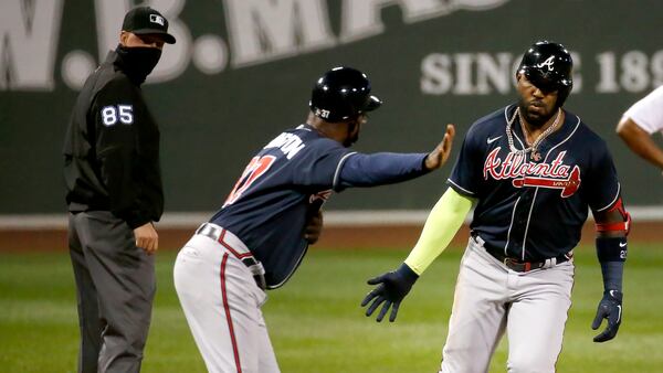 Atlanta Braves' Marcell Ozuna is congratulated by third base coach Ron Washington after hitting a two-run home run during the first inning of the team's baseball game against the Boston Red Sox, Tuesday, Sept. 1, 2020, in Boston. (AP Photo/Mary Schwalm)