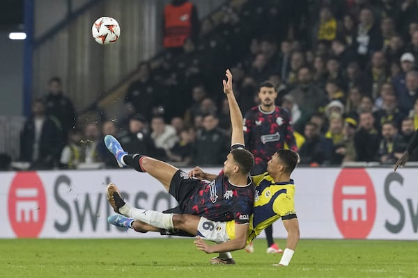 Rangers' Cyriel Dessers, left, fights for the ball with Fenerbahce's Alexander Djiku during the Europa League round of 16 first leg soccer match between Fenerbahce and Rangers at Sukru Saracoglu stadium in Istanbul, Turkey, Thursday, March 6, 2025. (AP Photo/Khalil Hamra)