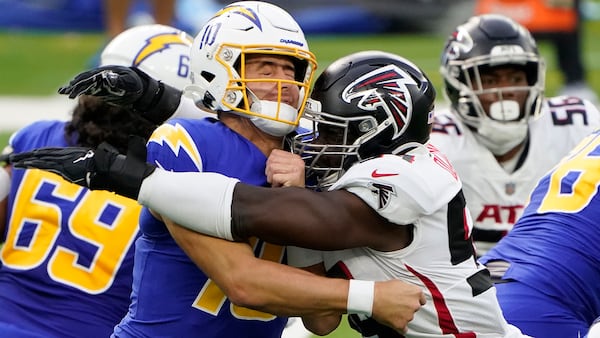 Los Angeles Chargers quarterback Justin Herbert (left) is hit by Atlanta Falcons linebacker Foyesade Oluokun as he throws during the first half Sunday, Dec. 13, 2020, in Inglewood, Calif. (Jae C. Hong/AP)