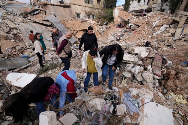 Displaced residents react as they stand in front of the rubble of their destroyed house in Baalbek, eastern Lebanon, Thursday, Nov. 28, 2024. (AP Photo/Hassan Ammar)