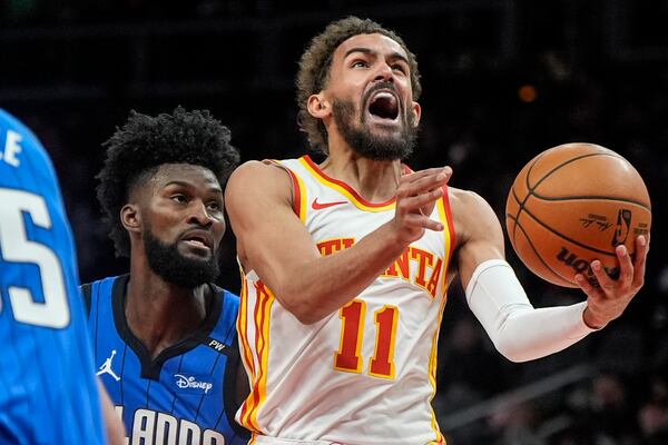 Atlanta Hawks guard Trae Young (11) heads to the basket against Orlando Magic forward Jonathan Isaac (1) during the first half of an NBA basketball game, Thursday, Feb. 20, 2025, in Atlanta. (AP Photo/Mike Stewart)