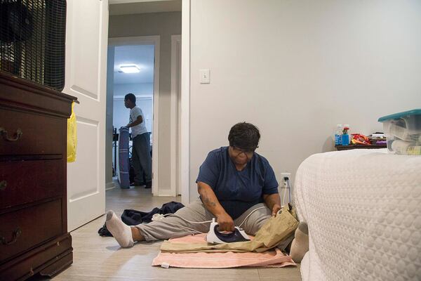 Pearl Lilly irons a pair of pants for her grandson's school uniform as everyone gets ready for school on Wednesday, Feb. 26, 2020. ALYSSA POINTER/ALYSSA.POINTER@AJC.COM