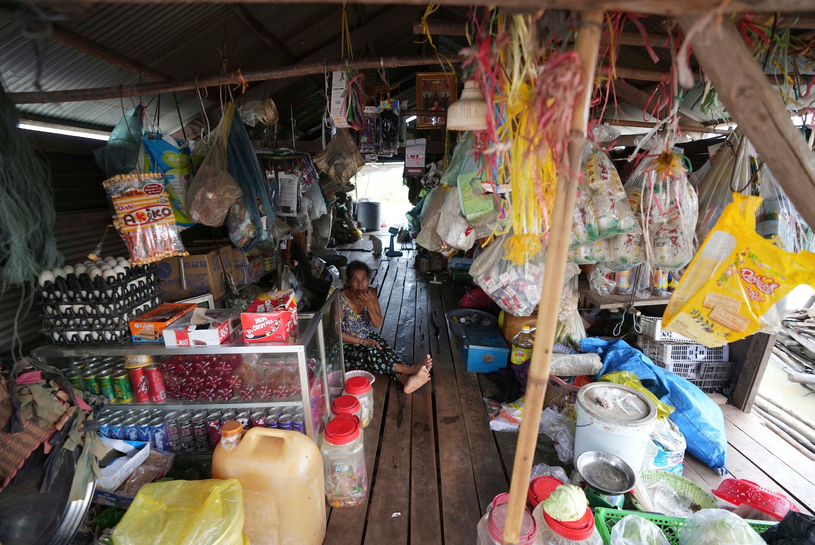 A local vendor sits at her grocery store at a floating village by the Tonle Sap in Kampong Chhnang province, Cambodia, Thursday, Aug. 1, 2024, (AP Photo/Heng Sinith)