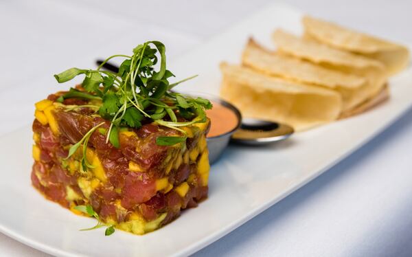 Tuna tartare at Bulla gets a new look, served with mango, avocado and miniature hard taco shells. CONTRIBUTED BY HENRI HOLLIS