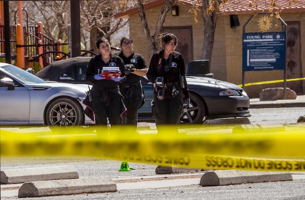 Crime scene technicians investigate the parking lot at Young Park after Friday night's fatal shooting in Las Cruces, N.M., on Saturday, March 22, 2025. (Chancey Bush/The Albuquerque Journal via AP)