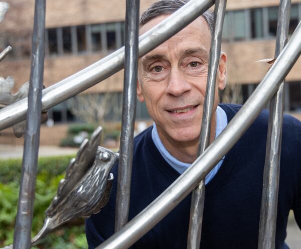 Eric Busko stands near one of the 22 cardinals in the iron gate at the Shepherd Center's Secret Garden. PHIL SKINNER FOR THE ATLANTA JOURNAL-CONSTITUTION