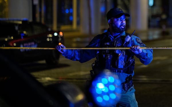 An Atlanta police officer secures the scene after a shooting at the 17th Street bridge near Atlantic Station left one person dead and several injured Saturday night.