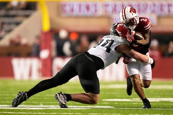 Wisconsin's Trech Kekahuna (2) is styopped by Oregon's Teitum Tuioti (44) during the first half of an NCAA college football game Saturday, Nov. 16, 2024, in Madison, Wis. (AP Photo/Morry Gash)