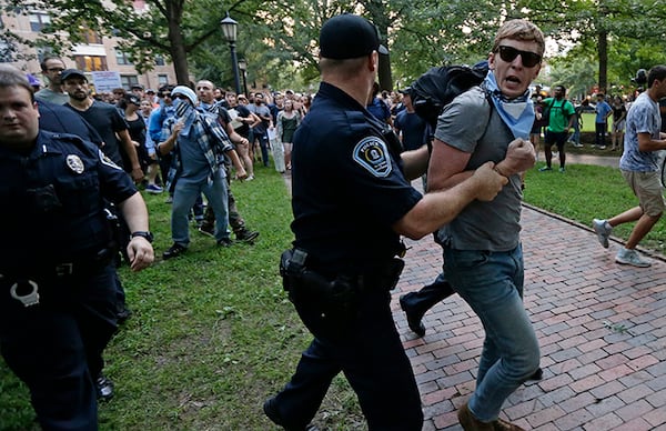 Police remove a protester during a rally to remove the Confederate statue known as Silent Sam from the campus at the University of North Carolina in Chapel Hill.