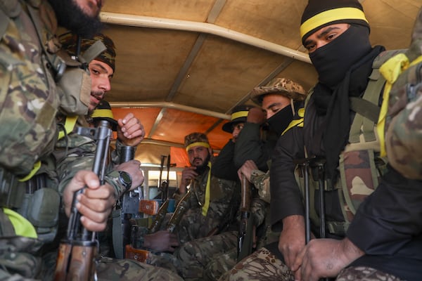 Syrian opposition fighters ride in a truck as they enter areas controlled by the Assad regime in Anjara, western outskirts of Aleppo, Syria, Thursday Nov. 29, 2024. Syrian armed groups launched a large-scale attack on areas controlled by government forces and seized territory in northwestern Syria, opposition groups said Thursday.(AP Photo/Omar Albam)