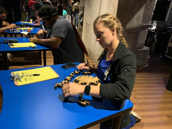 Claire Jackson trying to solve a "Survivor"-like puzzle during the watch party at Ron Clark Academy Oct. 27, 2021. RODNEY HO/rho@ajc.com