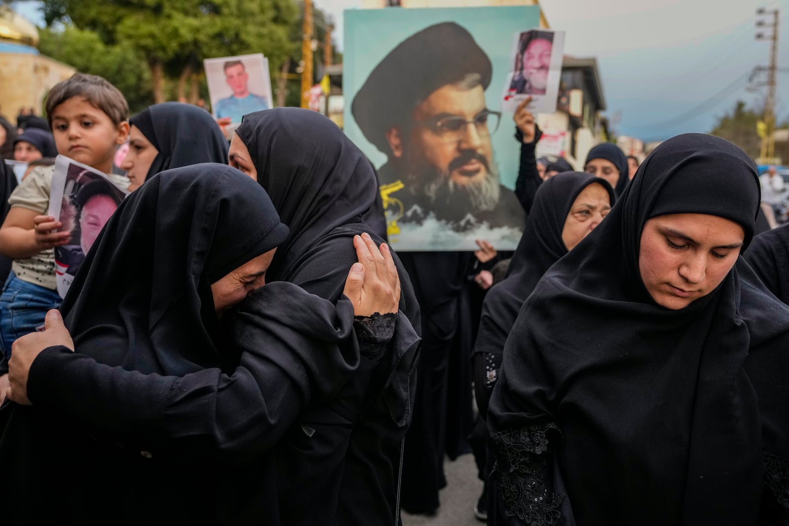 Mourners carry a picture of slain Hezbollah leader Hassan Nasrallah during the funeral procession of their relatives, in Maisara near the northern coastal town of Byblos, Lebanon, Monday, Oct. 14, 2024. (AP Photo/Hassan Ammar)