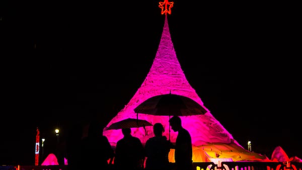 People stand under umbrellas as it rains at the 2016 tree lighting of Sandi at the West Palm Beach Waterfront. (Greg Lovett / The Palm Beach Post)