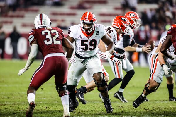 Georgia offensive lineman Broderick Jones (59) protects quarterback JT Daniels during a game against South Carolina Saturday, Nov. 28, 2020, at Williams-Brice Stadium in Columbia, SC. (Tony Walsh/UGA)