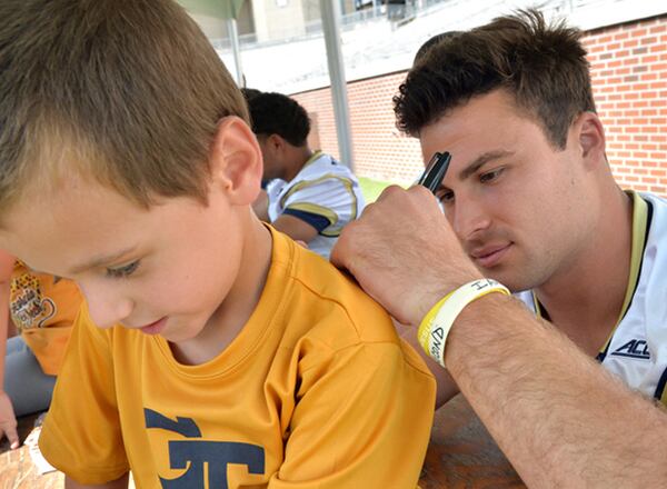 Georgia Tech quarterback Tim Byerly accomodates a young fan at last year's fan day. (AJC photo by Hyosub Shin)