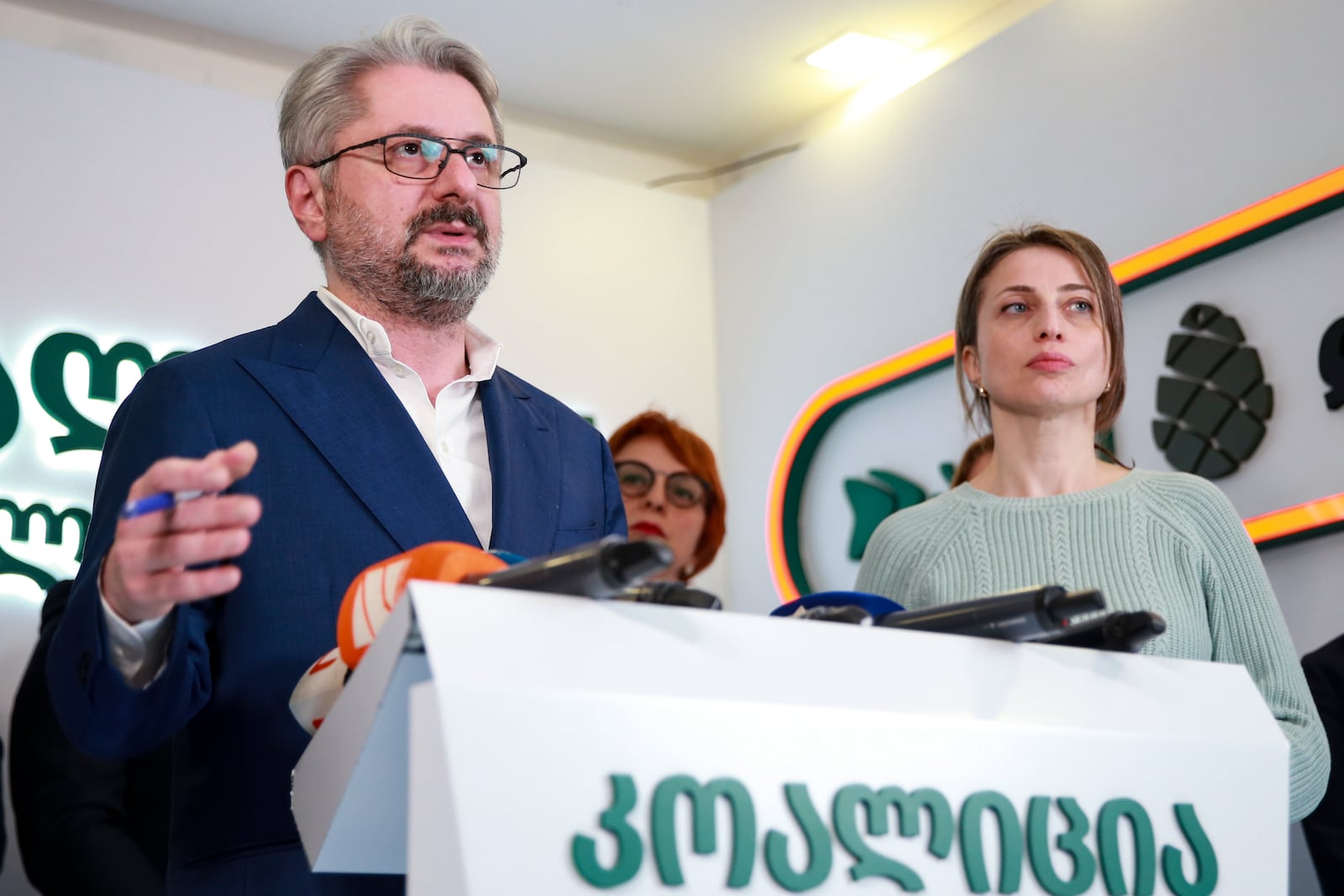 Nika Gvaramia, leader of Coalition for Changes, left, speaks to the media as and Nana Malashkhia, who leads the Coalition for Change parliament list, right, stands near, at coalition's headquarters after the parliamentary election in Tbilisi, Georgia, Sunday, Oct. 27, 2024. (AP Photo/Zurab Tsertsvadze)