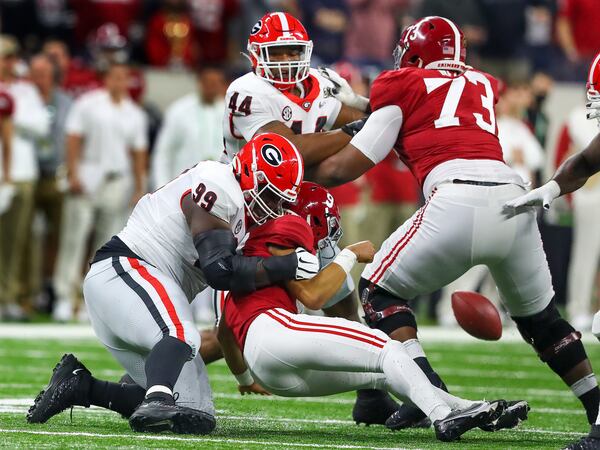 1/10/22 - Indianapolis -Georgia Bulldogs defensive lineman Jordan Davis (99) strips the ball from  Alabama Crimson Tide quarterback Bryce Young (9) in the first quarter.  Georgia recovered and appeared to score but it was ruled an incomplete pass at the 2022 College Football Playoff National Championship  between the Georgia Bulldogs and the Alabama Crimson Tide at Lucas Oil Stadium in Indianapolis on Monday, January 10, 2022.   Curtis Compton / Curtis.Compton@ajc.com 