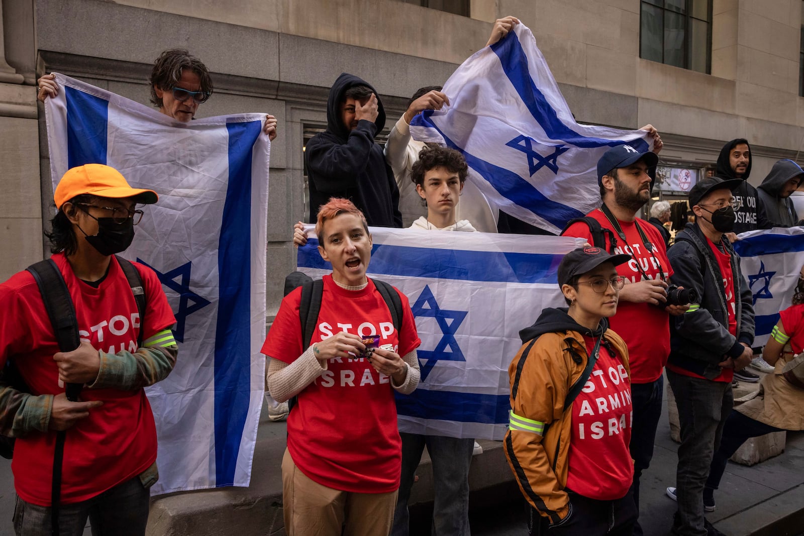 Pro-Israel protesters holds Israeli flags as demonstrators protest Israel's war against Hamas outside the New York Stock Exchange, Monday, Oct. 14, 2024, in New York. (AP Photo/Yuki Iwamura)