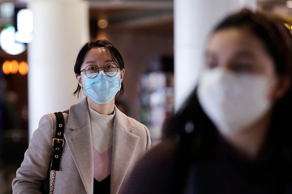 Travelers at Seattle-Tacoma International Airport wear protective face masks Tuesday.