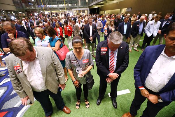 052422 Atlanta: Insurance Commissioner John King, his wife Carol, and Governor Brian Kemp supporters pray for the shooting victims in Texas during Kemp's election night party at the College Football Hall of Fame on Tuesday, May 24, 2022, in Atlanta.    “Curtis Compton / Curtis.Compton@ajc.com”