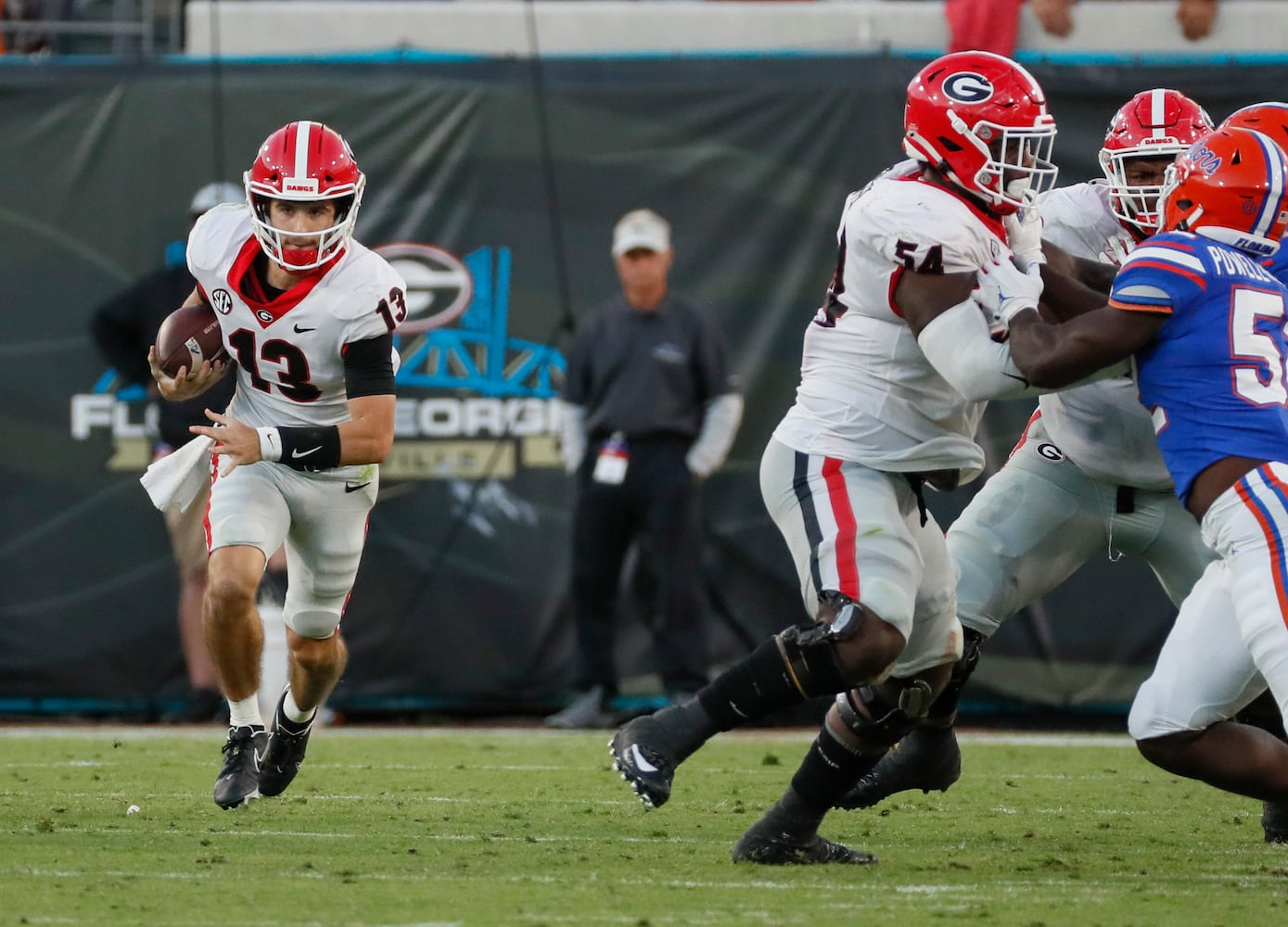 10/30/21 - Jacksonville - Georgia Bulldogs quarterback Stetson Bennett (13) scrambles for a first down during the second half of the annual NCCA  Georgia vs Florida game at TIAA Bank Field in Jacksonville. Georgia won 34-7.  Bob Andres / bandres@ajc.com