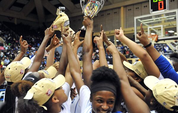 MARCH 7, 2015 MACON McEachern Indians players celebrate with the championship trophy. Coverage of Class AAAAAA girls state championship game between the McEachern Indians and the Norcross Blue Devils in the Georgia High School Basketball championships at the Macon Coliseum, Saturday, March 7, 2015. Norcross led 32-25 at the half. The McEachern Indians beat Norcross, 58-51 in overtime. KENT D. JOHNSON/KDJOHNSON@AJC.COM McEachern Indians players celebrate with the Class AAAAAA girls championship trophy. (Kent D. Johnson / AJC)