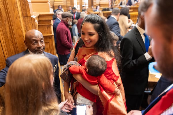 State Sen. Nabilah Islam Parkes, D-Duluth, exchanges greetings after being sworn in on first day of the legislative session at the Capitol in Atlanta on Monday.