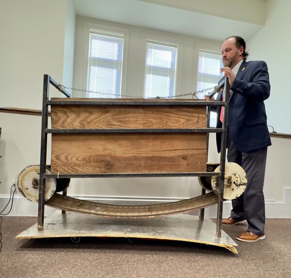 Jones County sheriff's investigator Barron Hall wheels in evidence that prosecutors described as a homemade treadmill, used to condition fighting dogs, on Wednesday in Jones County Superior Court. (Joe Kovac Jr./AJC)