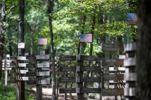 09/09/2021 — Athens, Georgia — The names of victims are written upon wooden posts at a 9/11 memorial walking trail created by Bob Hart in Athens, Thursday, September 9, 2021.  (Alyssa Pointer/Atlanta Journal Constitution)