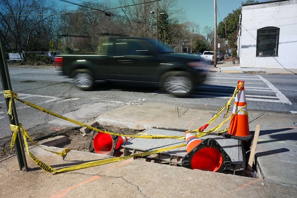 A damaged part of the sidewalk is shown as automobiles travel on Boulevard SE as it crosses the intersection with Woodward Ave, Friday, February, 21, 2025, in Atlanta. This intersection is one of a several slated for upgrades under infrastructure bond program projects (Jason Getz / AJC)