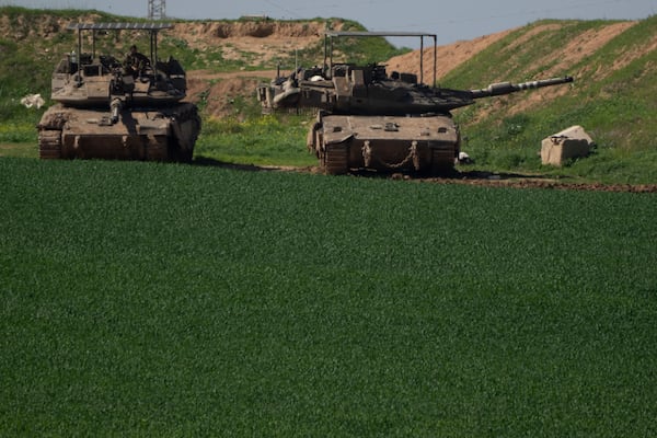 An Israeli soldier sits on the top of a tank near Israeli-Gaza border, as seen from southern Israel, Sunday, March 2, 2025. (AP Photo/Leo Correa)