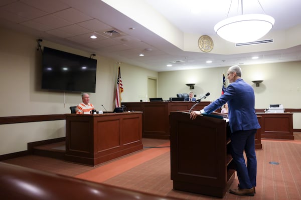 District Attorney Brad Smith, right, speaks with Colin Gray, father of Colt Gray, as Gray testifies in the court room of Barrow County Superior Court Judge Nicholas Primm at Barrow County Courthouse Superior Court on Feb. 11 in Winder, Ga. Colin Gray is the father of 14-year-old Colt Gray, accused of fatally shooting two teachers and two students at Apalachee High School.  (Jason Getz/AJC)