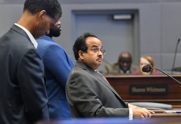 July 14, 2021 Atlanta - Michel "Marty" Turpeau IV, chairman of DAFC, standing with Sam Bacote (left), treasurer of DAFC and Kyle Lamont (second from left), member of DAFC, answers questions from the elected Fulton commissioners at the Fulton County government building in Atlanta on Wednesday, July 14, 2021. Michel "Marty" Turpeau IV, chairman of the embattled Development Authority of Fulton County (DAFC), announced Monday he will end his dual role as interim executive director, effective Aug. 31. (Hyosub Shin / Hyosub.Shin@ajc.com)