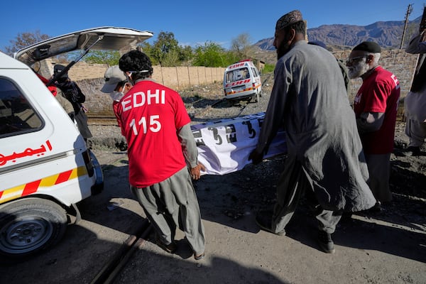 Rescue workers transport a coffin containing the body of a victim from a passenger train attacked by insurgents, upon arrival at a railway station in Much, Pakistan's southwestern Balochistan province, Thursday March 13, 2025. (AP Photo/Anjum Naveed)